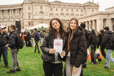 Zwei Mädchen halten einen Flyer der Karriereplattform